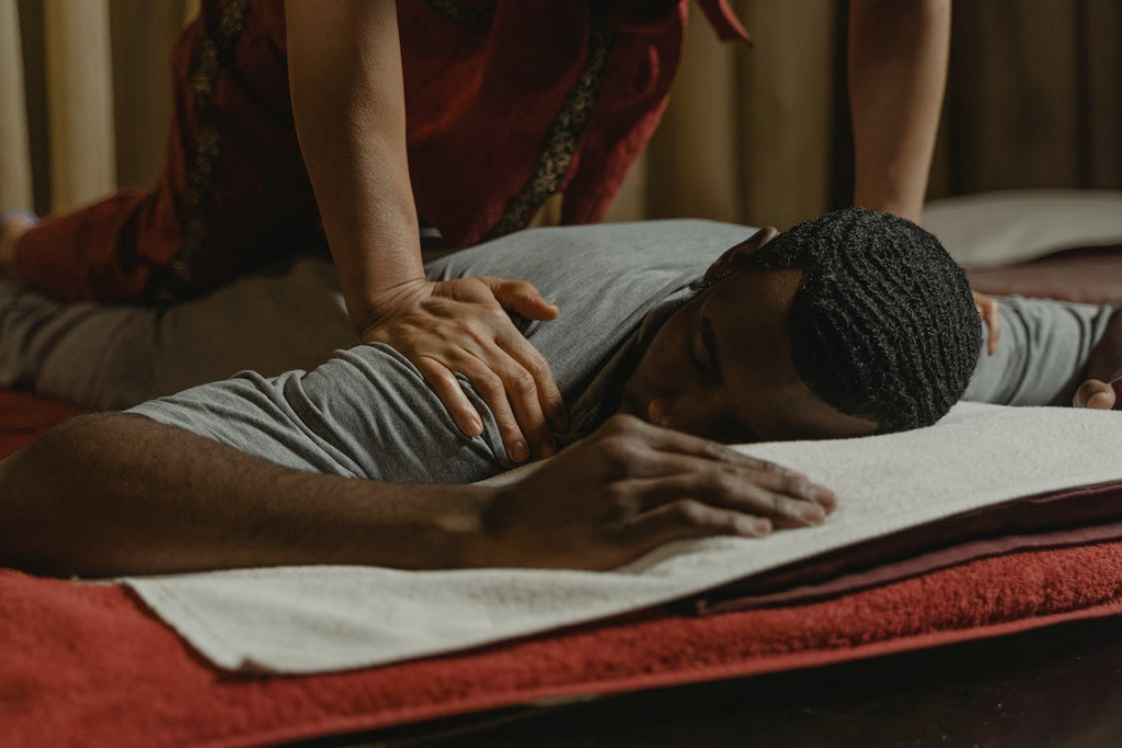 A masseuse massaging a person’s shoulders