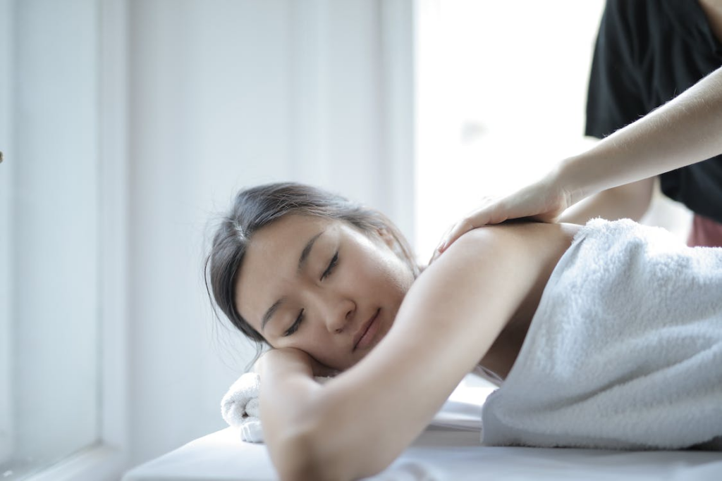 A woman in a massage towel relaxing during an Asian therapy massage by Asian Massage 2 You 